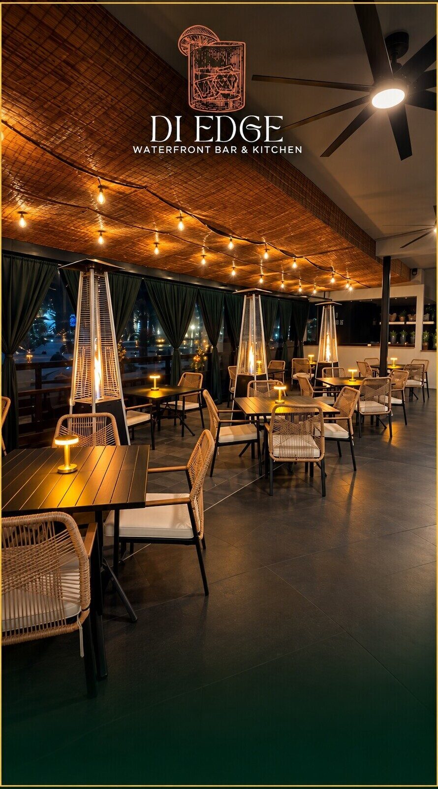 The Di Edge terrace at night, string lights over rattan chairs and the water beyond